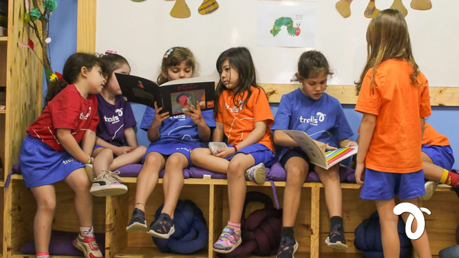 Turma de alunos da Trails School lendo em roda